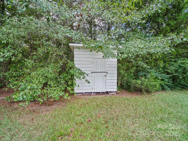 front view of a house with a small yard and large trees