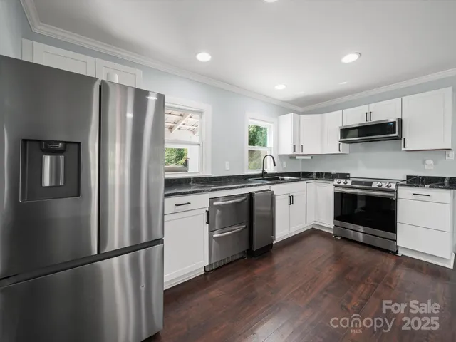 a kitchen with a refrigerator a sink and a stove top oven