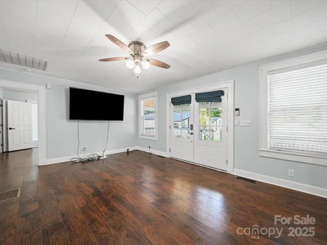 an empty space with wooden floor and windows