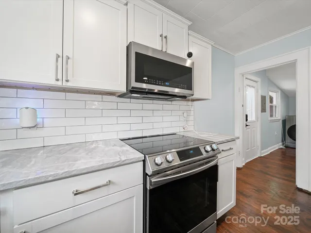 a kitchen with stainless steel appliances a stove microwave and sink