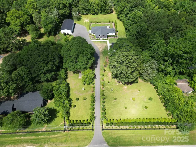 an aerial view of a residential houses with yard