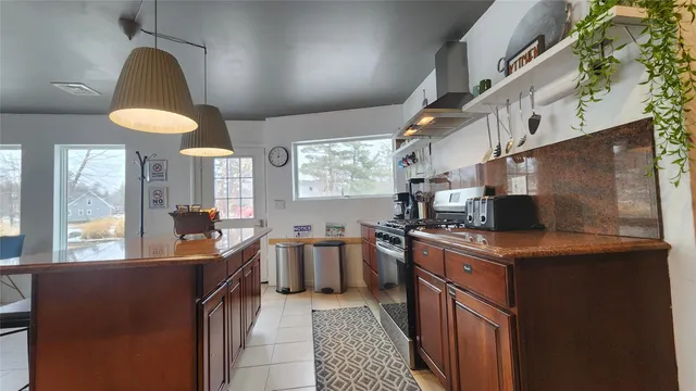 a kitchen with stainless steel appliances granite countertop a sink a stove and a refrigerator