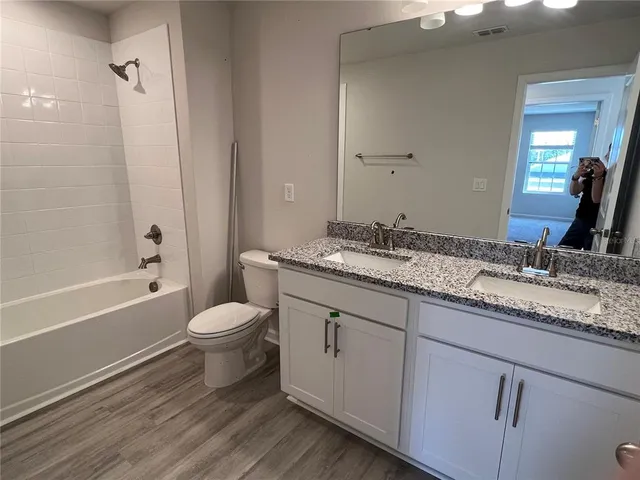 a bathroom with a granite countertop toilet sink and mirror