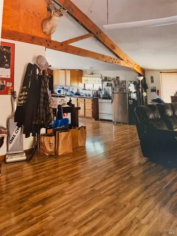 a living room with lots of furniture and a kitchen view