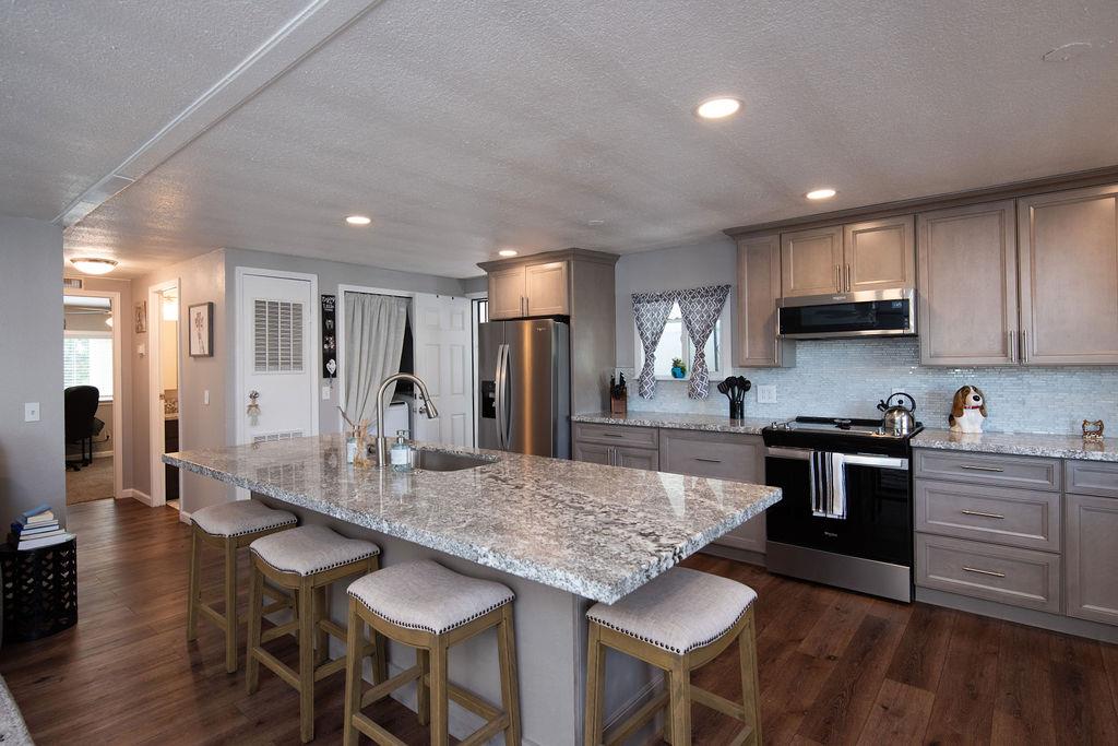 a kitchen with stainless steel appliances granite countertop a stove top oven a table and chairs