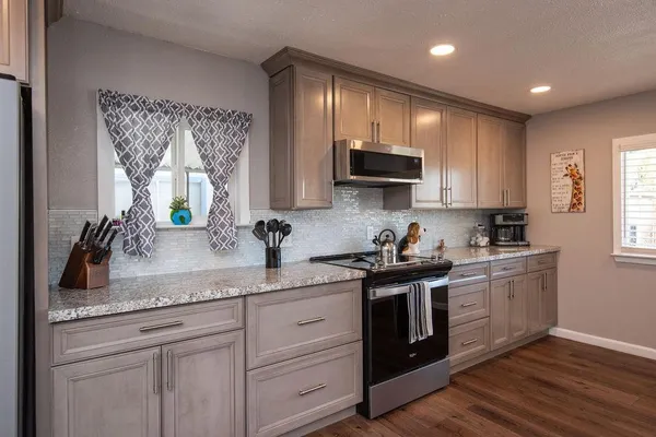 a kitchen with stainless steel appliances granite countertop a sink and stove top oven