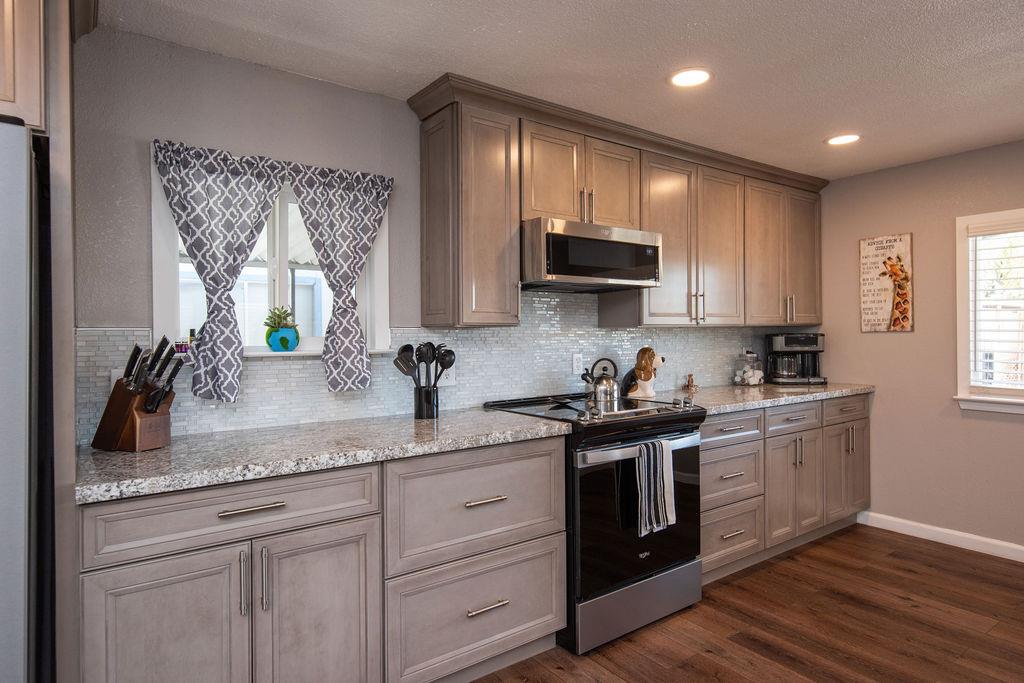 107 Schooner Lane Modesto, CA 95356 - Photo 11 of 43 a kitchen with stainless steel appliances granite countertop a sink and stove top oven