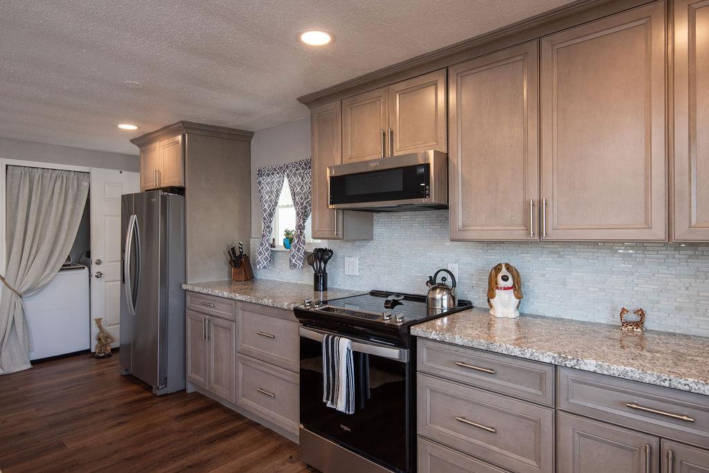 107 Schooner Lane Modesto, CA 95356 - Photo 12 of 43 a kitchen with stainless steel appliances granite countertop a refrigerator sink and cabinets
