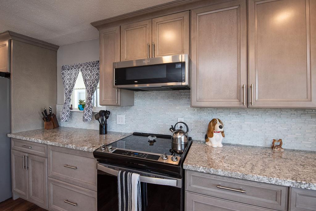 107 Schooner Lane Modesto, CA 95356 - Photo 14 of 43 a kitchen with granite countertop a sink a stove and cabinets