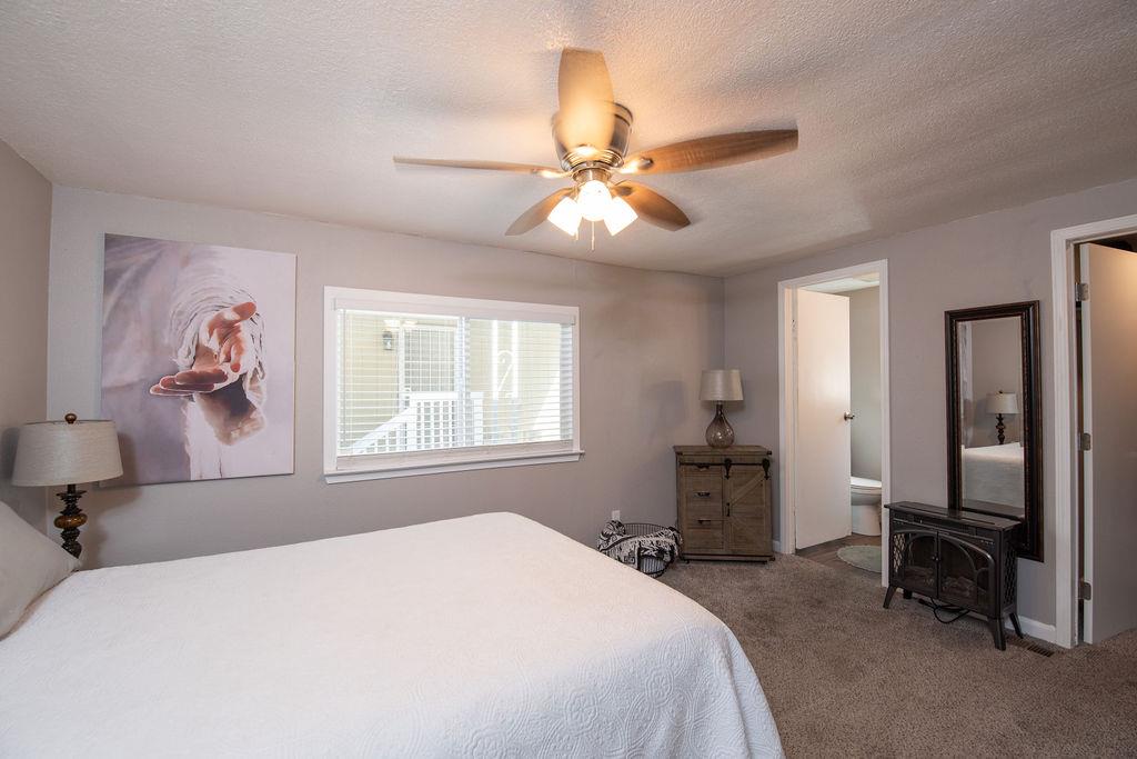 107 Schooner Lane Modesto, CA 95356 - Photo 18 of 43 a bedroom with a bed and a chandelier