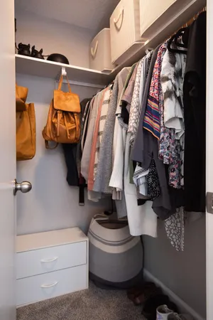a view of walk in closet with clothes and shoes