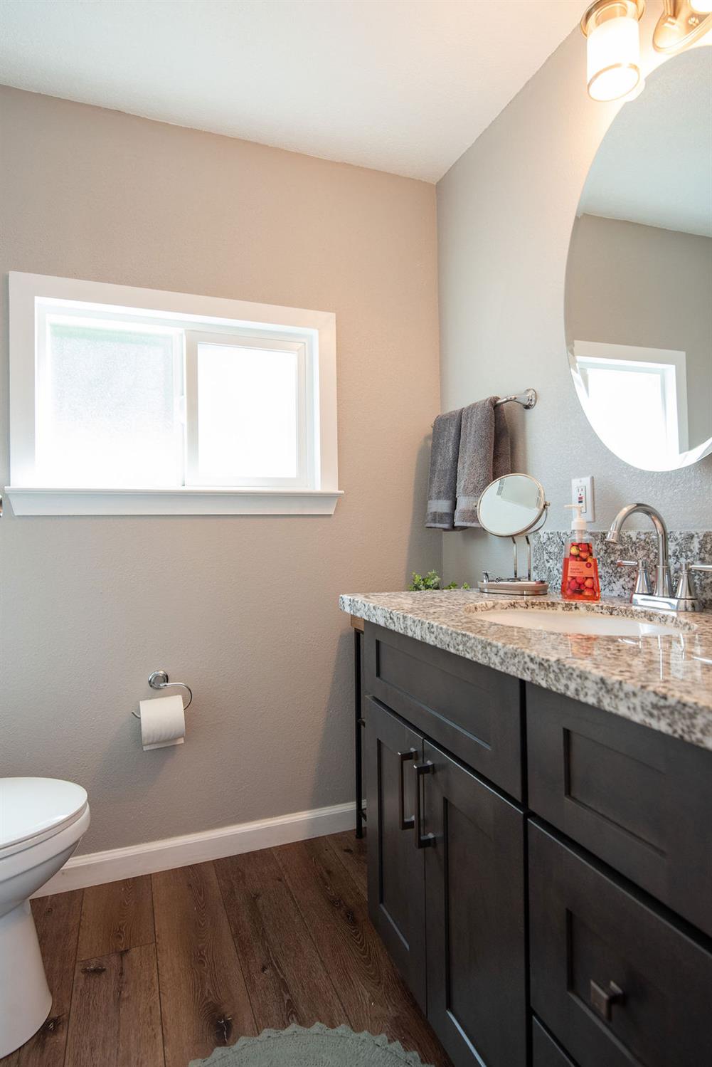 107 Schooner Lane Modesto, CA 95356 - Photo 23 of 43 a bathroom with a granite countertop sink a toilet and a window