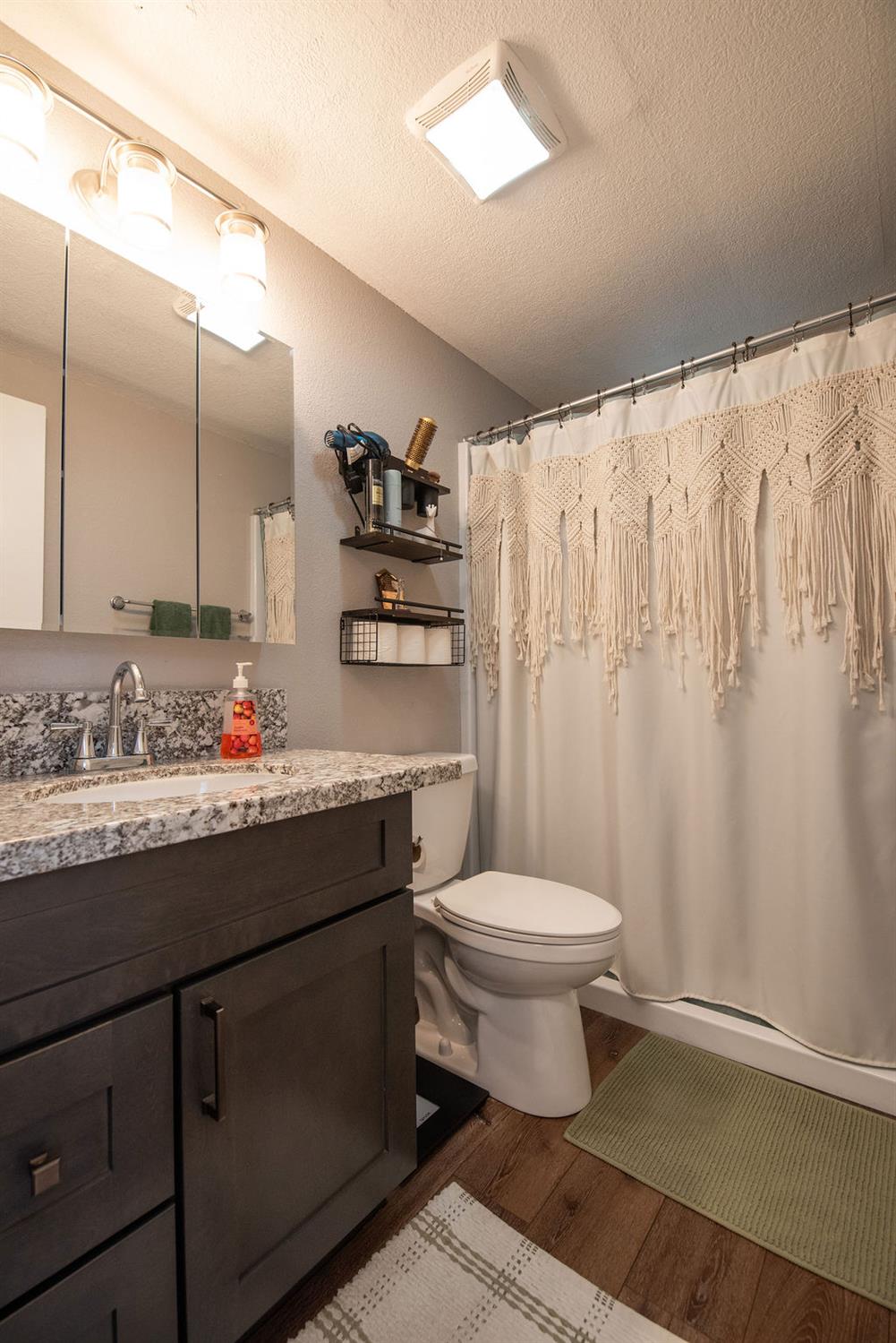 107 Schooner Lane Modesto, CA 95356 - Photo 24 of 43 a bathroom with a granite countertop sink toilet and a mirror
