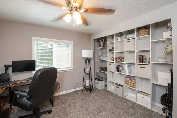 a view of a workspace with furniture and a window