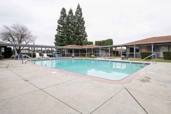 a view of a house with pool and sitting area