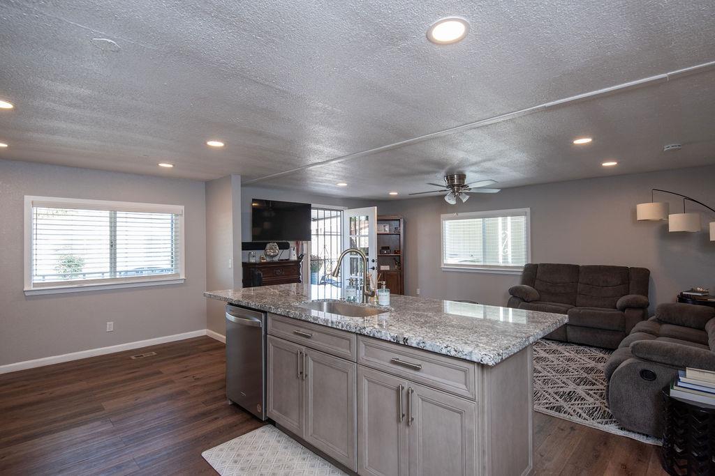 107 Schooner Lane Modesto, CA 95356 - Photo 9 of 43 a kitchen with granite countertop a sink cabinets and wooden floor