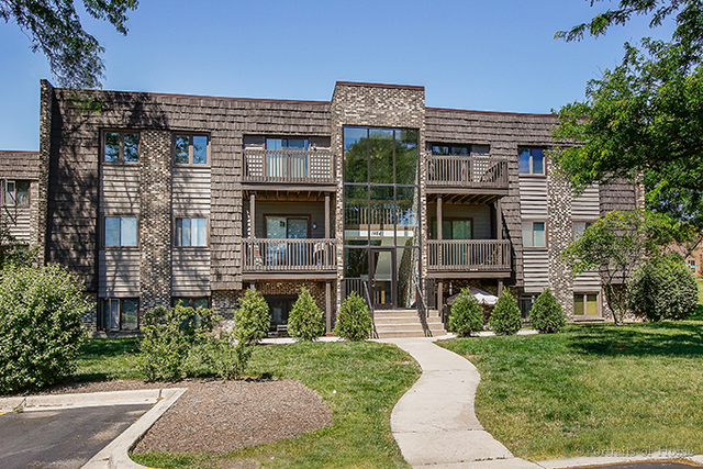 1464 Stonebridge Circle, Unit E3 Wheaton, IL 60189 - Photo 1 of 9 a front view of a house with a garden