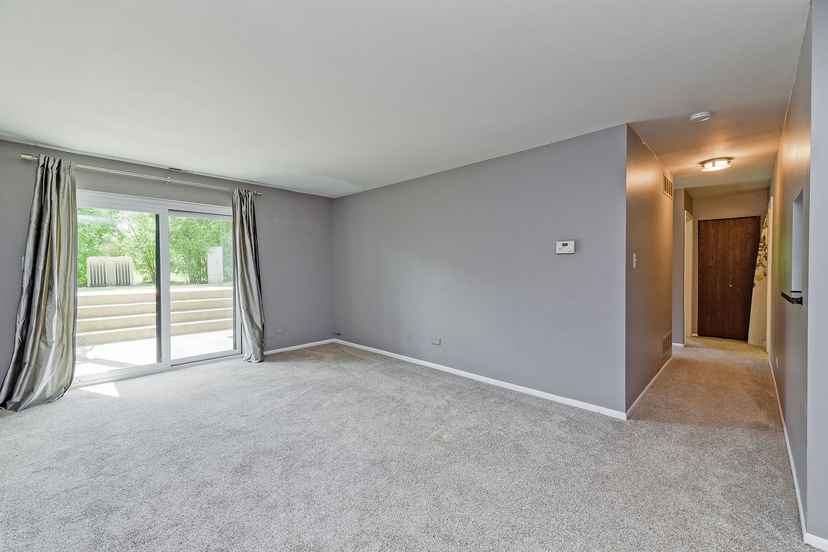 1464 Stonebridge Circle, Unit E3 Wheaton, IL 60189 - Photo 2 of 9 a view of an empty room with a balcony