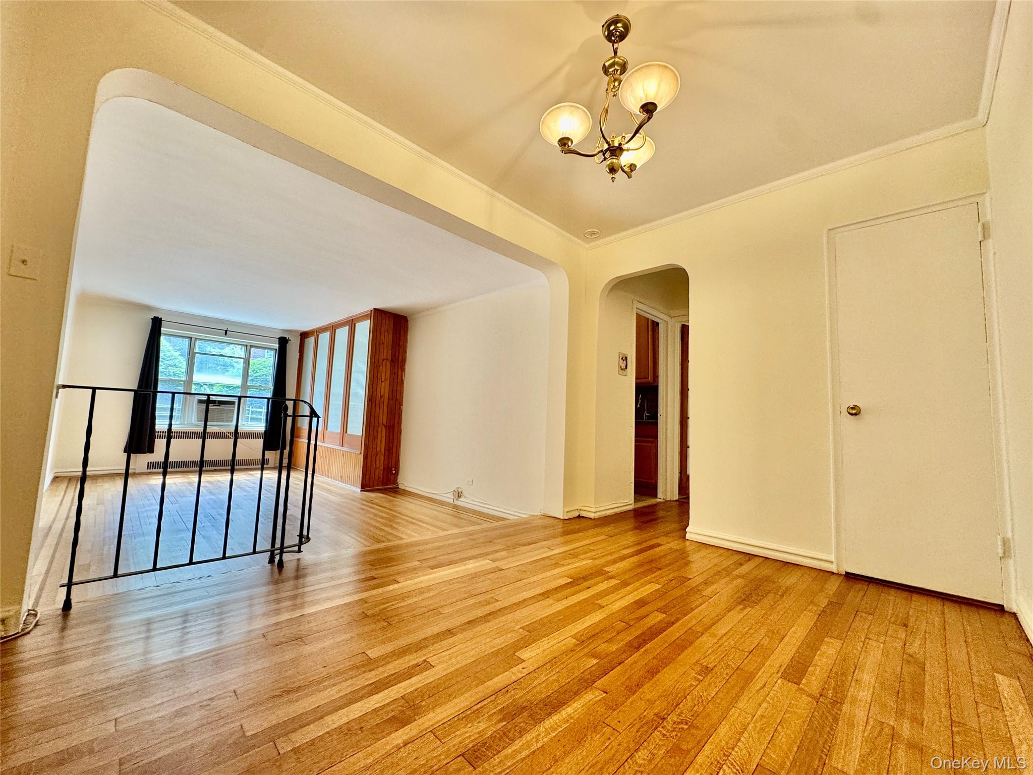 113-14 72nd Road, Unit 1M Queens, NY 11375 - Photo 3 of 20 a view of a livingroom with wooden floor and stairs