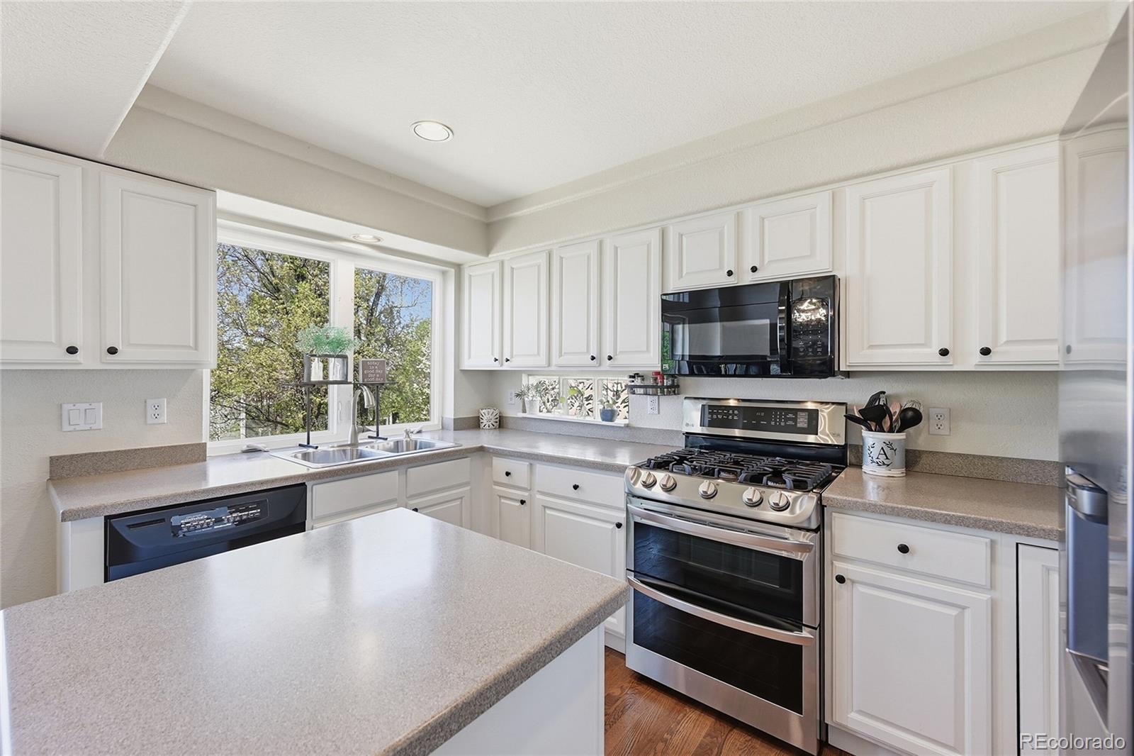 9153 Roadrunner Drive Highlands Ranch, CO 80129 - Photo 13 of 39 a kitchen with cabinets appliances a window and a counter space