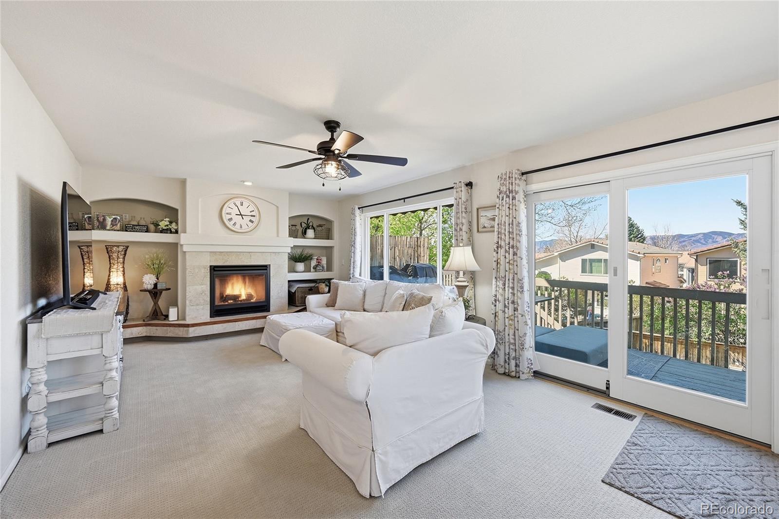 9153 Roadrunner Drive Highlands Ranch, CO 80129 - Photo 17 of 39 a living room with furniture a fireplace and a flat screen tv