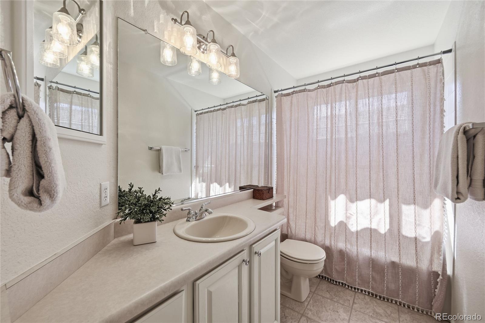 9153 Roadrunner Drive Highlands Ranch, CO 80129 - Photo 25 of 39 a bathroom with a sink toilet and tub