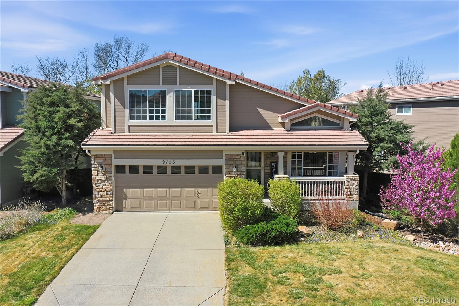 9153 Roadrunner Drive Highlands Ranch, CO 80129 - Photo 3 of 39 a front view of a house with a yard