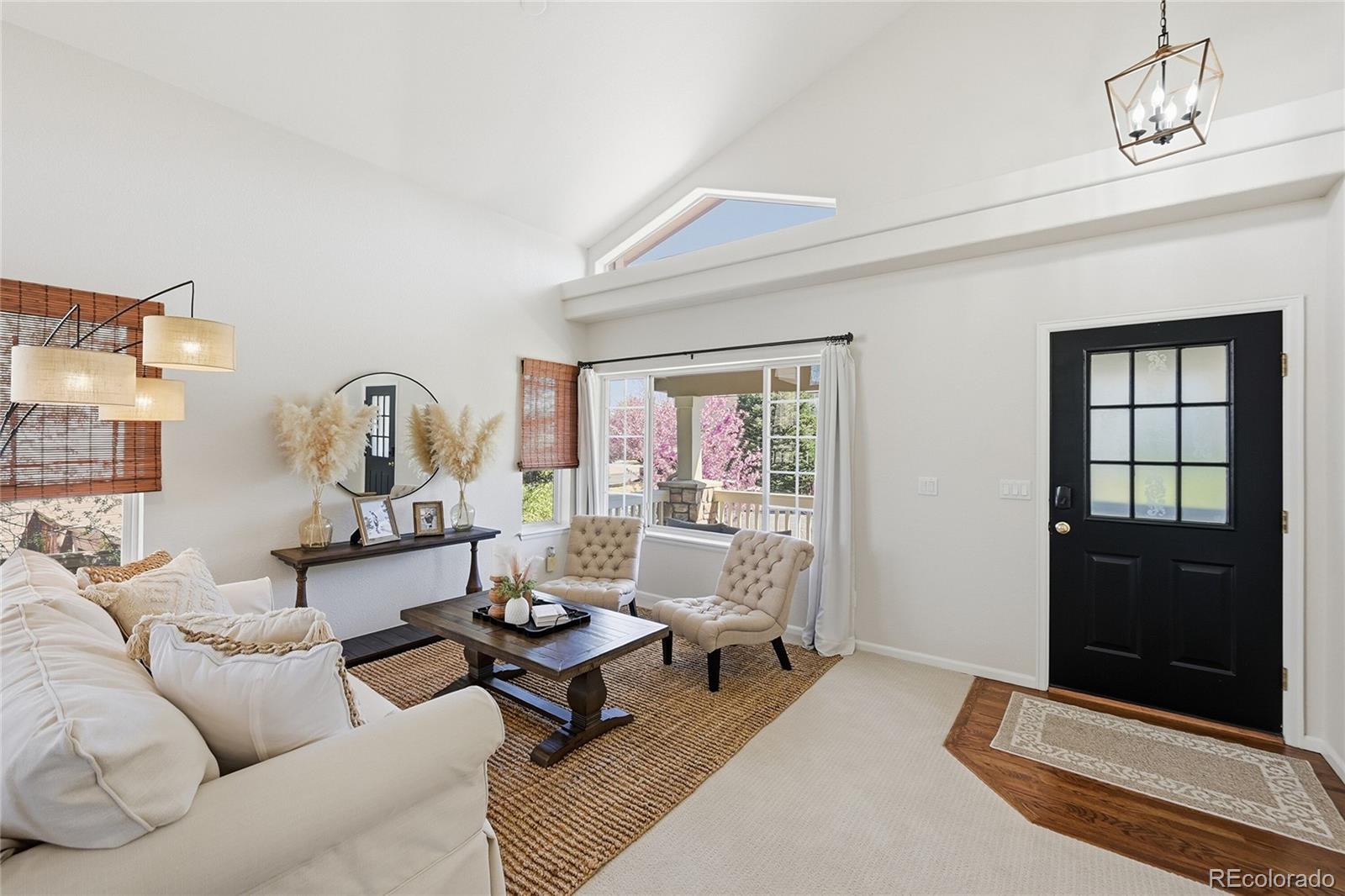 9153 Roadrunner Drive Highlands Ranch, CO 80129 - Photo 8 of 39 a living room with furniture a window and a chandelier