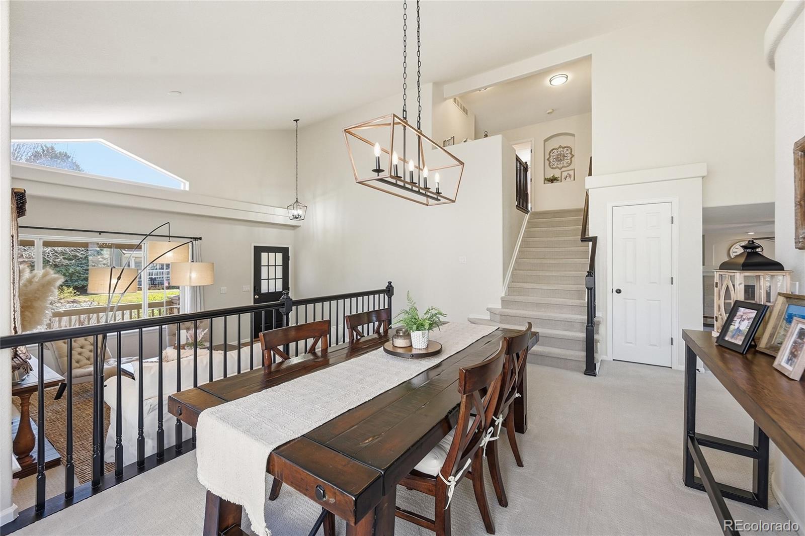 9153 Roadrunner Drive Highlands Ranch, CO 80129 - Photo 10 of 39 a view of a dining room with furniture a chandelier and wooden floor