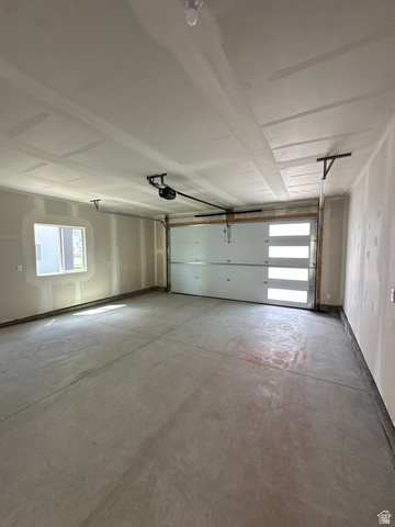 1225 West 500 South Logan, UT 84321 - Photo 19 of 39 Spacious two-car garage featuring a modern overhead door with frosted glass panels, an automatic garage door opener, and a single window for natural light