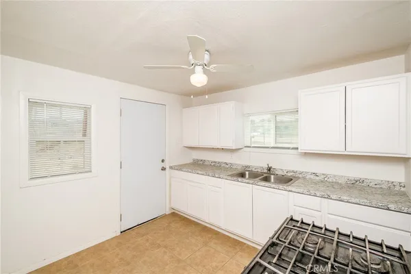 an empty room with windows and fan