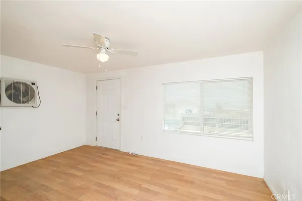 a view of a hallway with wooden floor and a living room