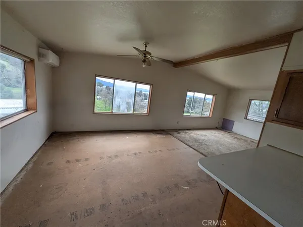 an empty room with windows and fireplace