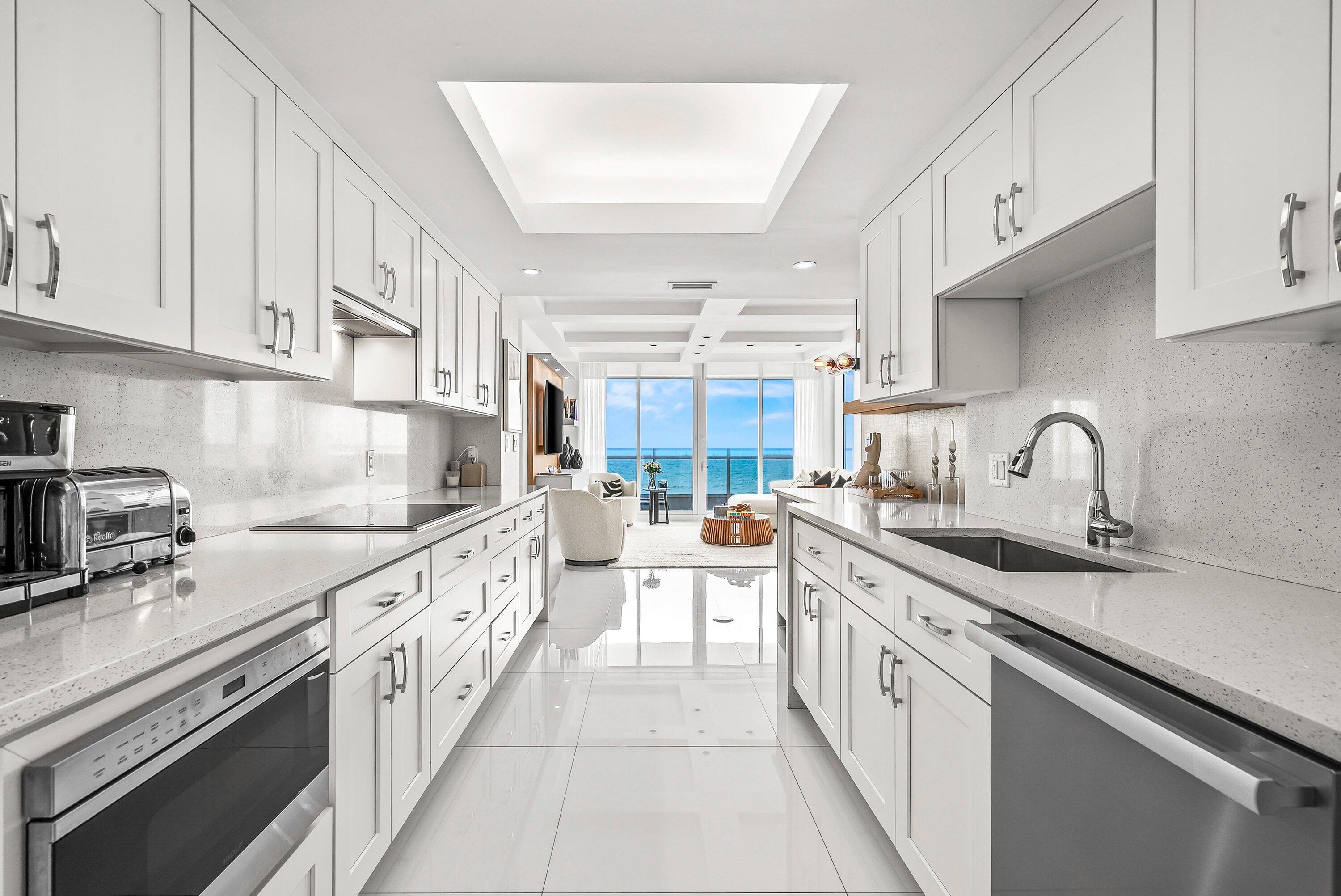 700 South Ocean Boulevard, Unit 705 Boca Raton, FL 33432 - Photo 4 of 58 a kitchen with kitchen island granite countertop a sink stainless steel appliances and cabinets