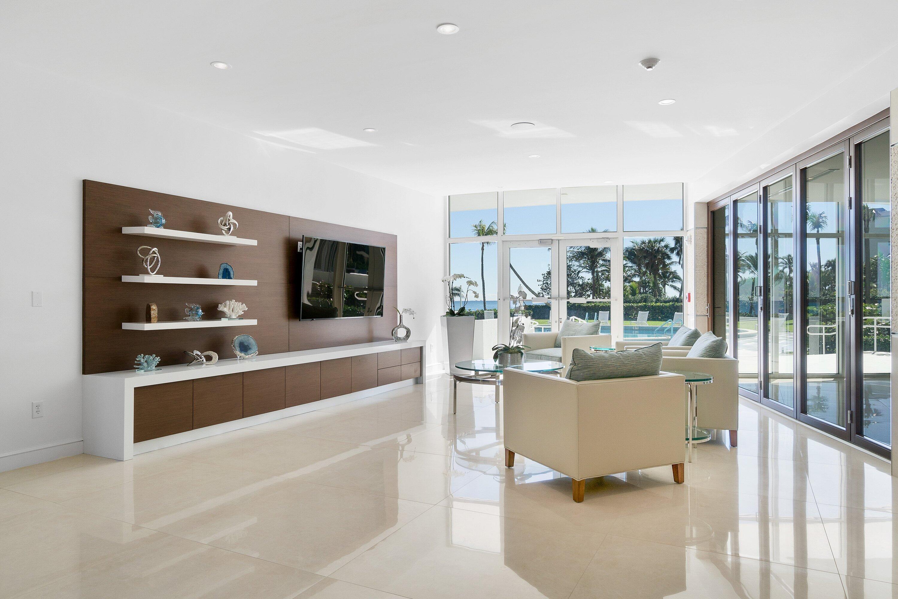 700 South Ocean Boulevard, Unit 705 Boca Raton, FL 33432 - Photo 43 of 58 a living room with furniture a flat screen tv and a floor to ceiling window