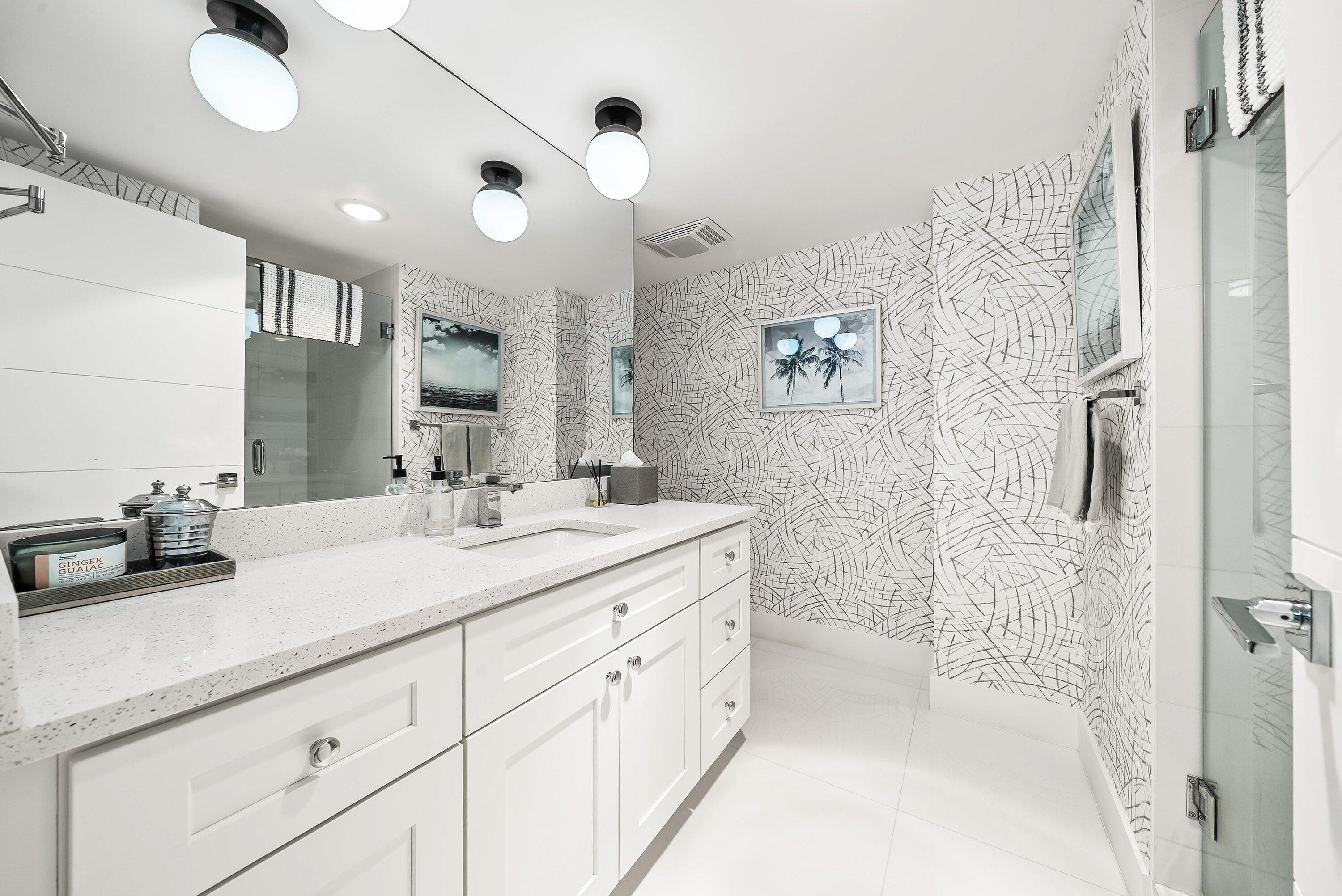 700 South Ocean Boulevard, Unit 705 Boca Raton, FL 33432 - Photo 6 of 58 a bathroom with a double vanity sink mirror and shower