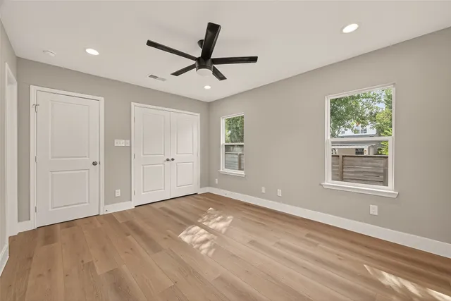 a view of empty room with wooden floor and window