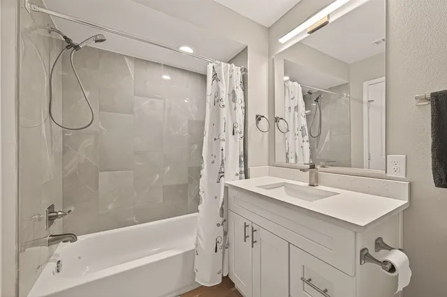 a bathroom with a sink double vanity mirror and a bathtub