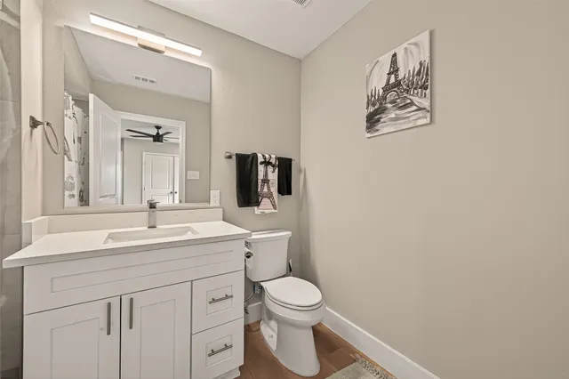a bathroom with a toilet sink vanity and mirror