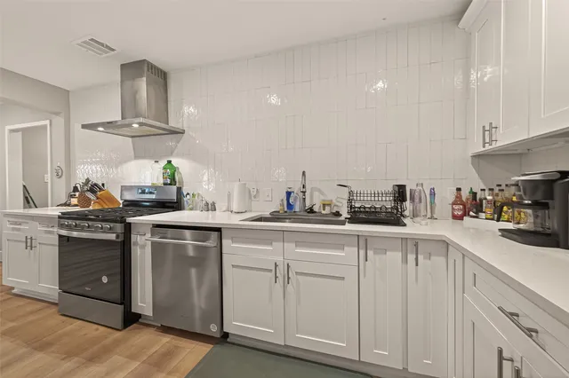 a kitchen with white cabinets and sink