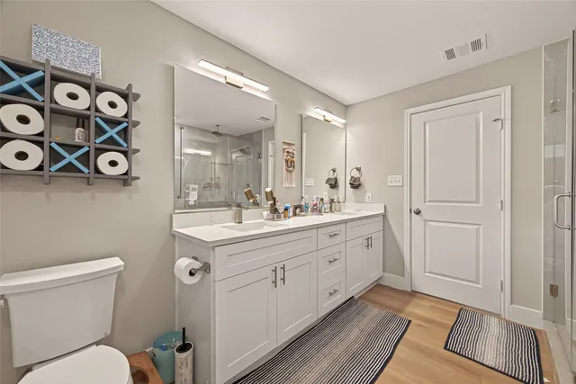a spacious bathroom with a double vanity sink and a toilet