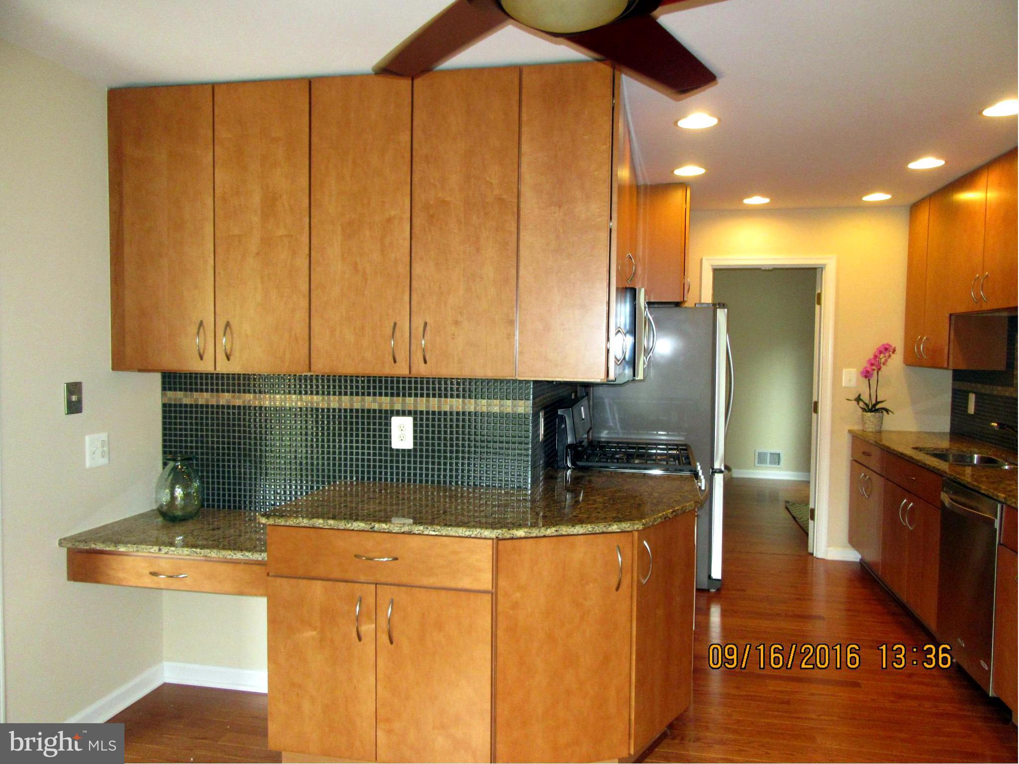 8638 Woodview Drive Springfield, VA 22153 - Photo 14 of 30 a kitchen with stainless steel appliances granite countertop a sink a stove and a refrigerator