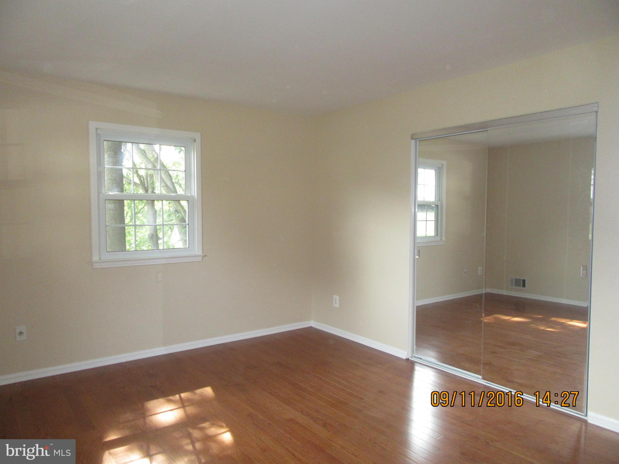 8638 Woodview Drive Springfield, VA 22153 - Photo 16 of 30 an empty room with wooden floor and windows