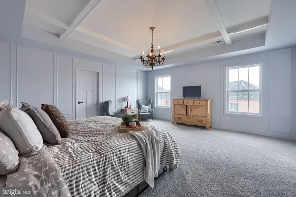 a spacious bedroom with a bed and a chandelier