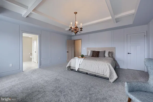 a bedroom with a large bed chandelier and a window