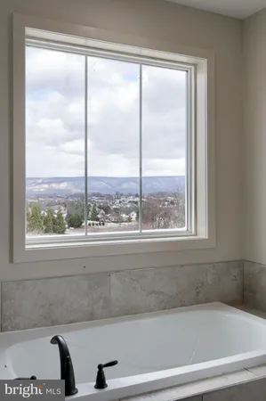 a bathroom with a bathtub and next to a window