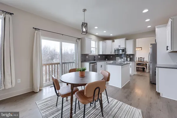 a kitchen with kitchen island a dining table and chairs