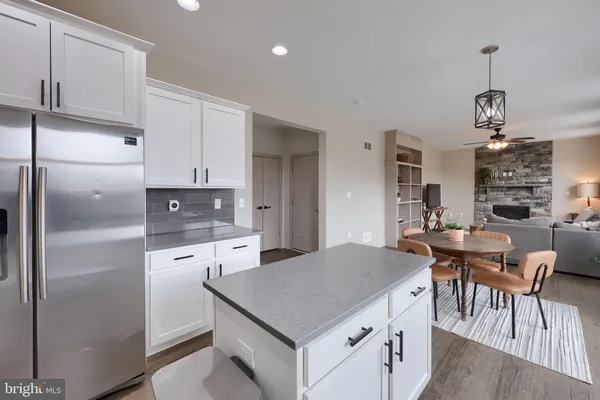 a kitchen with a refrigerator a kitchen island a stove a table and chairs