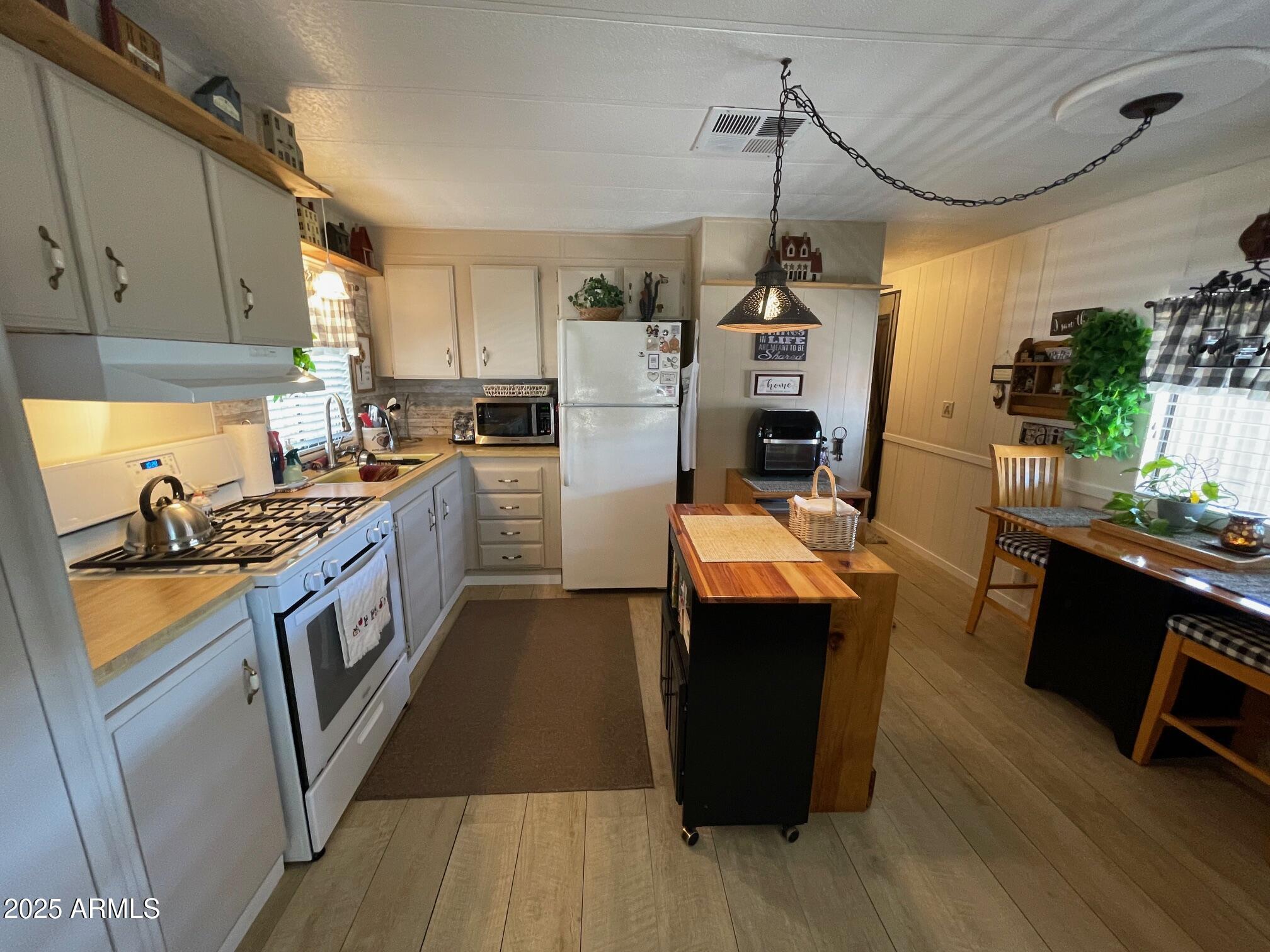 980 East Broadway Avenue, Unit 15 Apache Junction, AZ 85119 - Photo 11 of 24 a kitchen with granite countertop a sink dishwasher stove and refrigerator