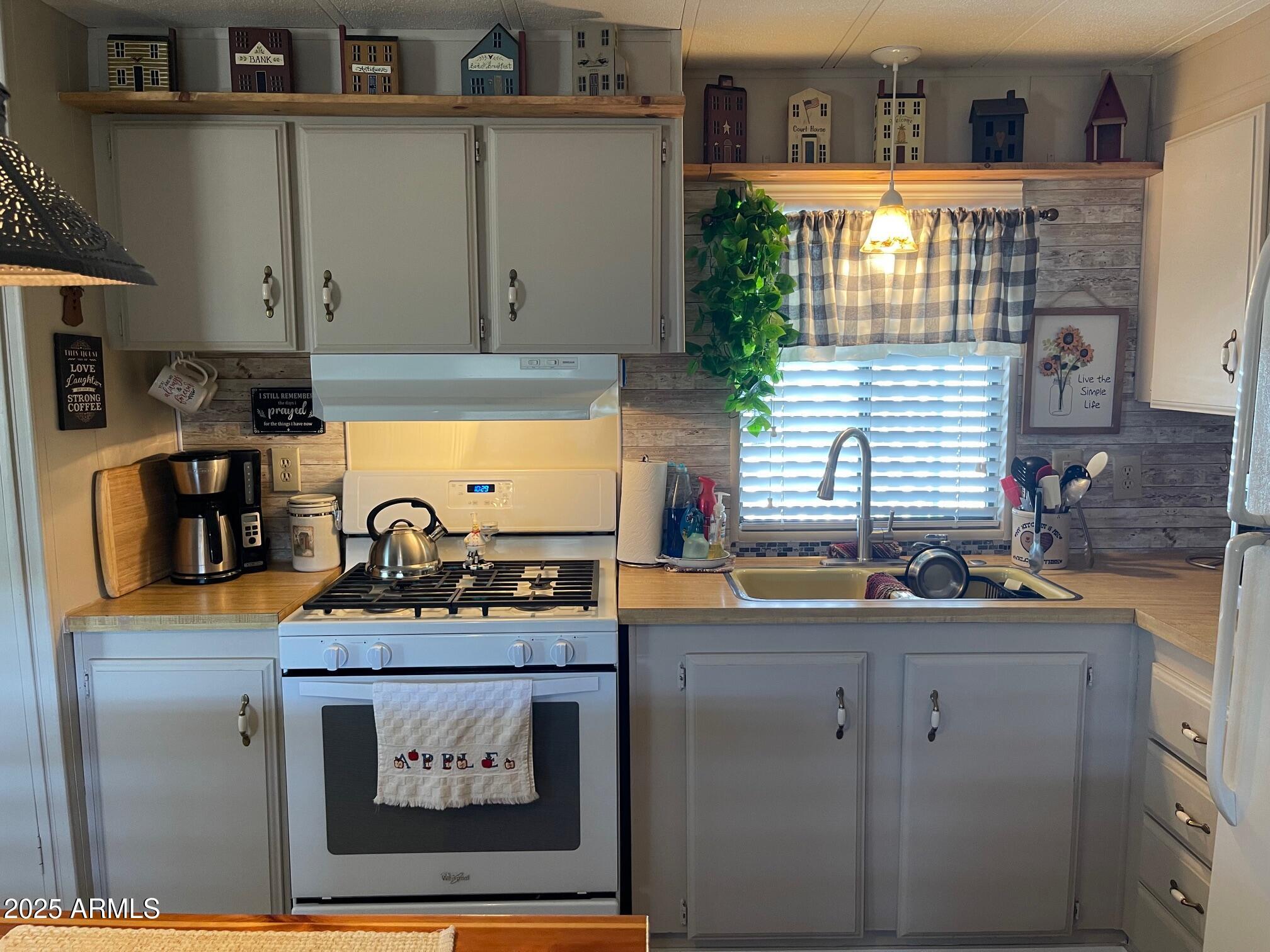 980 East Broadway Avenue, Unit 15 Apache Junction, AZ 85119 - Photo 13 of 24 a kitchen with stainless steel appliances granite countertop a sink stove and cabinets